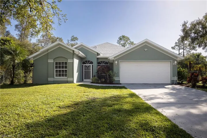 Ranch-style house with a garage and a front lawn