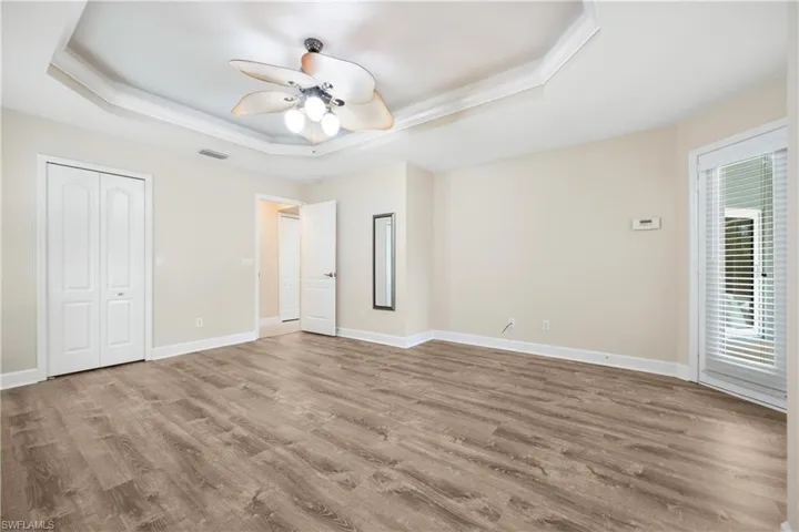 Unfurnished bedroom with light hardwood / wood-style floors, multiple windows, and ceiling fan