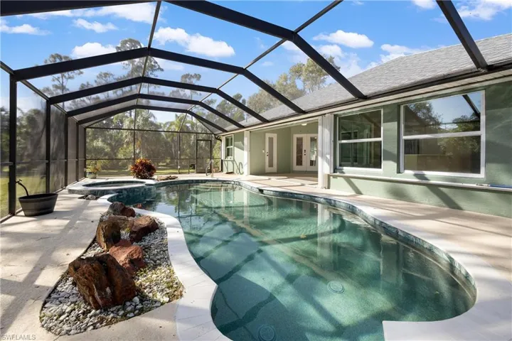 View of swimming pool featuring a patio area, a lanai, and an in ground hot tub