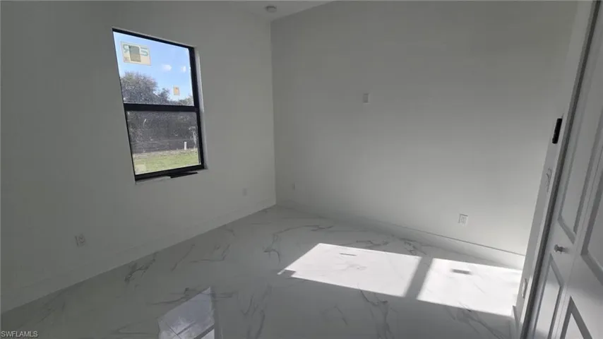 Unfurnished room with baseboards and light marble finish flooring