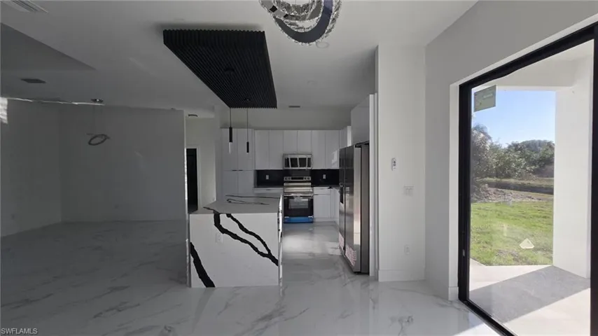 Kitchen featuring plenty of natural light, white cabinetry, stainless steel appliances, and modern cabinets