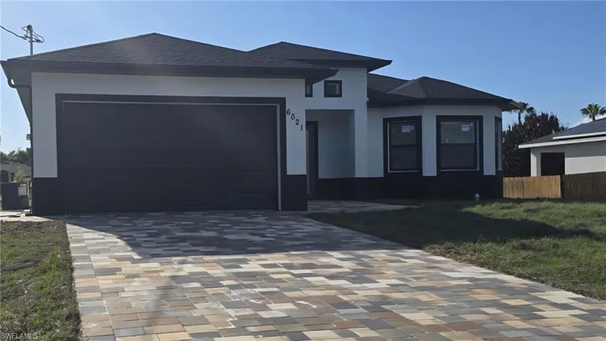 Prairie-style home with a garage, decorative driveway, roof with shingles, and stucco siding