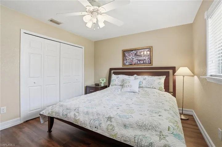 Spacious room featuring wood-finish flooring, a ceiling fan, and a window with blinds