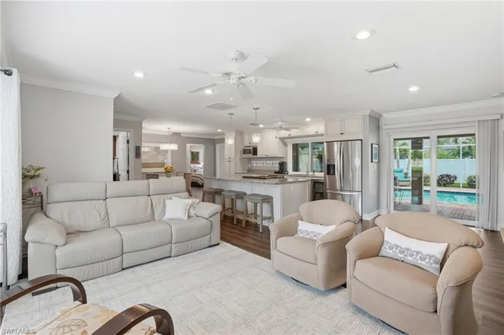 Expansive open-concept living area featuring wood-finish flooring and crown molding