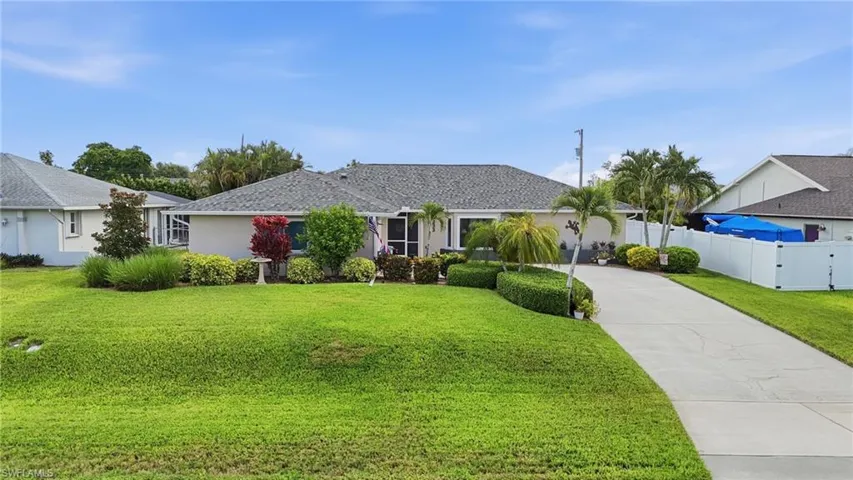 Single-story residence featuring a gray shingle roof and a light-colored exterior