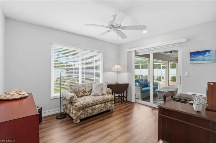 Interior room featuring wood-finish flooring, a ceiling fan, and light gray wall tones