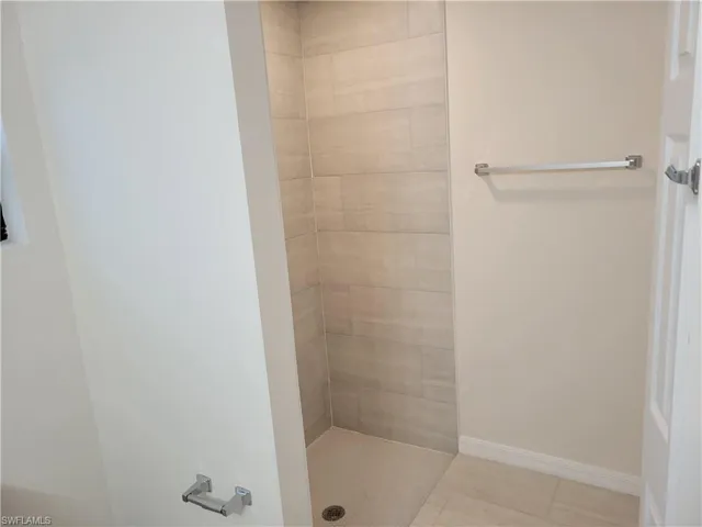 Bathroom featuring tile patterned floors and a tile shower