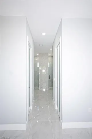 Corridor with baseboards and marble finish floor