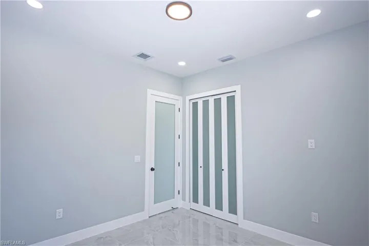 Unfurnished bedroom with baseboards, marble finish floor, recessed lighting, and visible vents