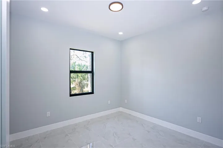 Empty room featuring recessed lighting, marble finish floor, and baseboards