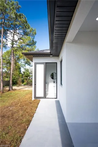 Property entrance with a lawn and stucco siding