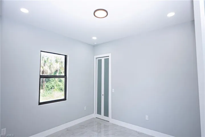 Spare room with baseboards, recessed lighting, and marble finish floor
