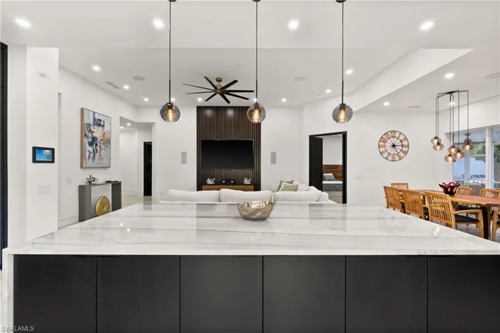Kitchen featuring a large island, ceiling fan, and decorative light fixtures