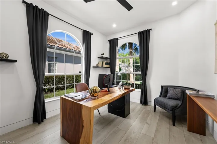 Office with a wealth of natural light, ceiling fan, and light wood-type flooring