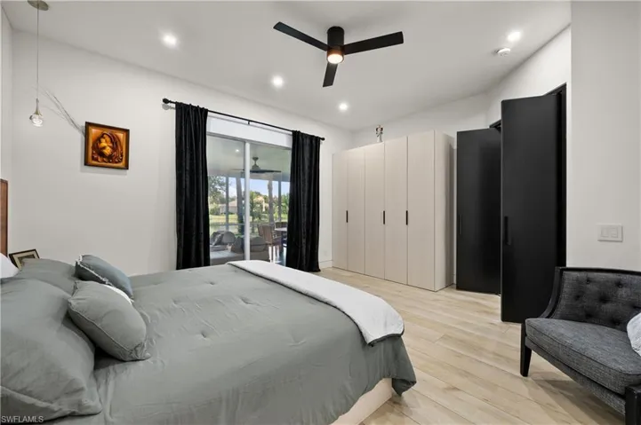 Bedroom with light wood-type flooring, access to outside, and ceiling fan