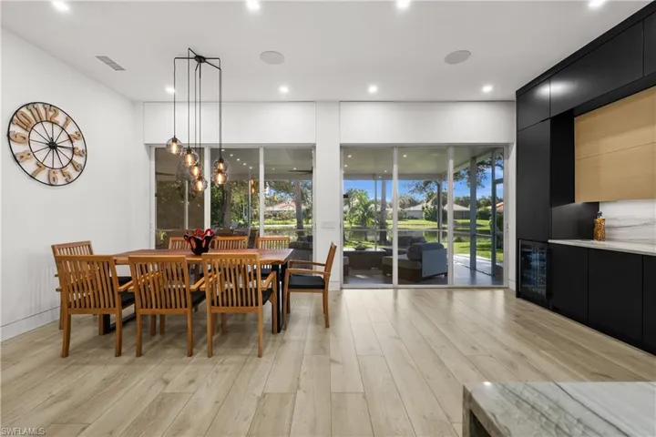 Dining space with a notable chandelier, light hardwood / wood-style floors, and a wealth of natural light