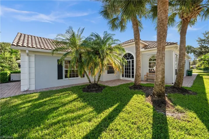 Back of property featuring a lawn and a patio area