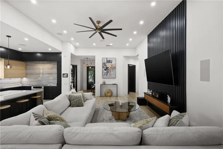 Living room with light hardwood / wood-style floors and ceiling fan
