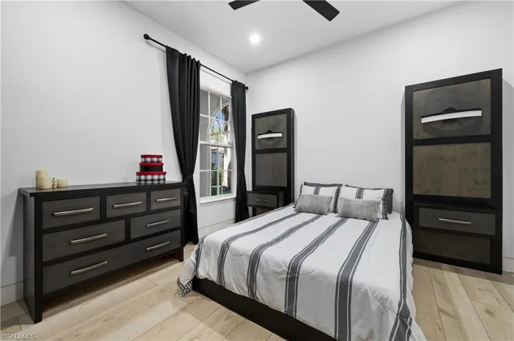 Bedroom with ceiling fan and light wood-type flooring