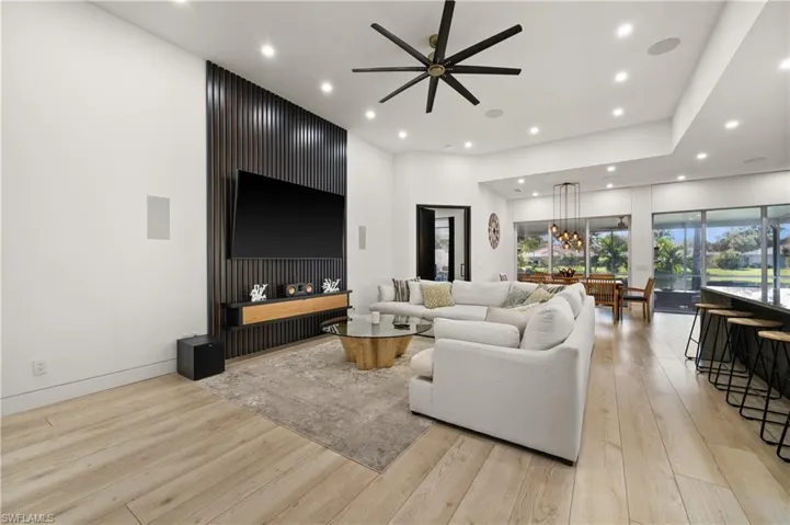 Living room with light hardwood / wood-style floors and ceiling fan