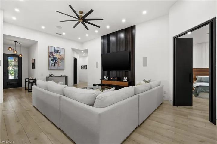 Living room with ceiling fan and light hardwood / wood-style flooring