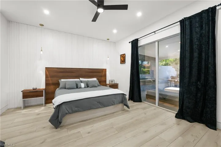 Bedroom with light wood-type flooring, ceiling fan, and access to exterior