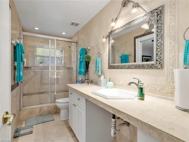 Bathroom with vanity, a shower stall, and recessed lighting