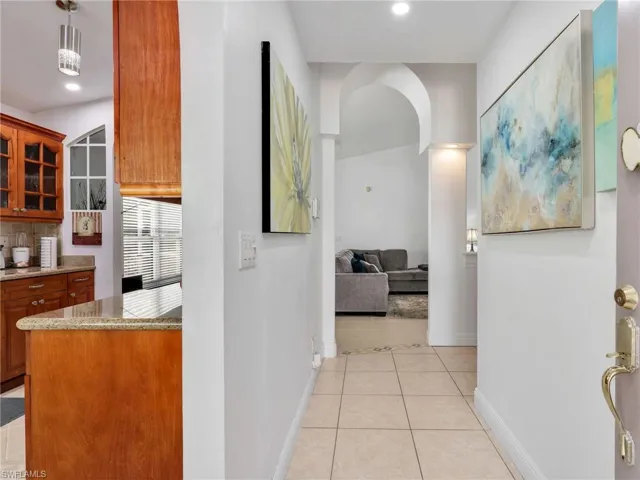 Hall with light tile patterned flooring and recessed lighting
