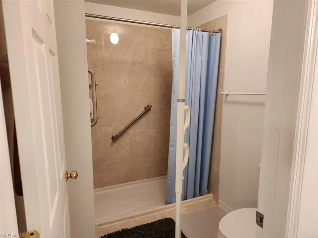 Bathroom featuring wheelchair access shower and toilet