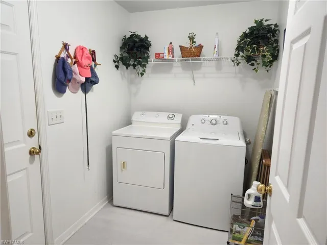 Laundry room with washing machine and dryer and shelving