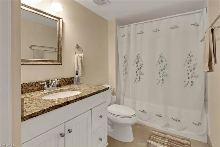 Full bath featuring vanity, light tile patterned floors, and shower / bath combo