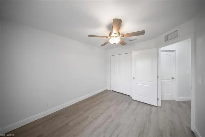 Unfurnished bedroom with light wood-style flooring, a ceiling fan, and a closet