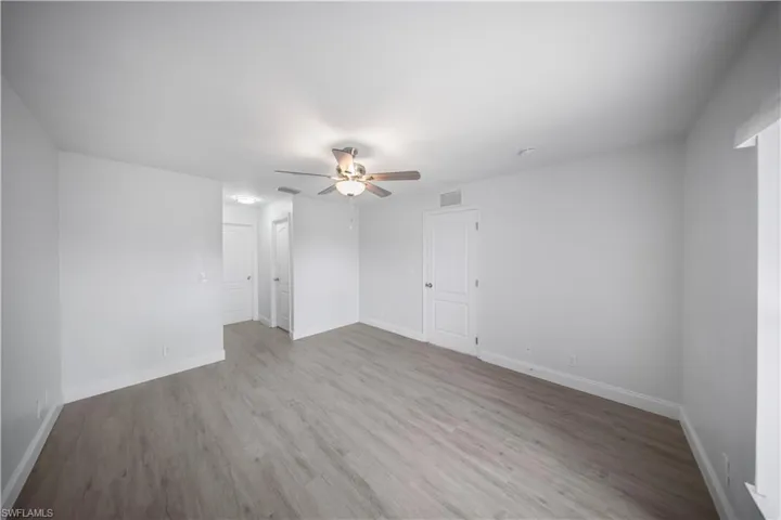 Spare room with light wood finished floors and ceiling fan