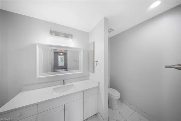 Bathroom with vanity and light marble finish floors