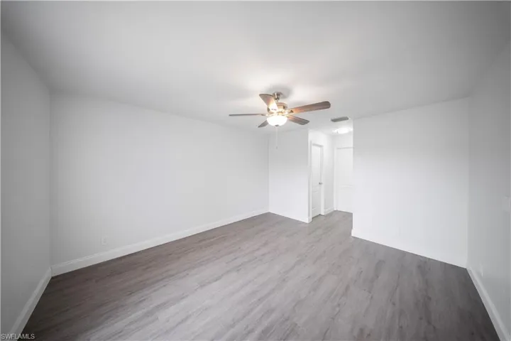 Empty room with wood finished floors and a ceiling fan