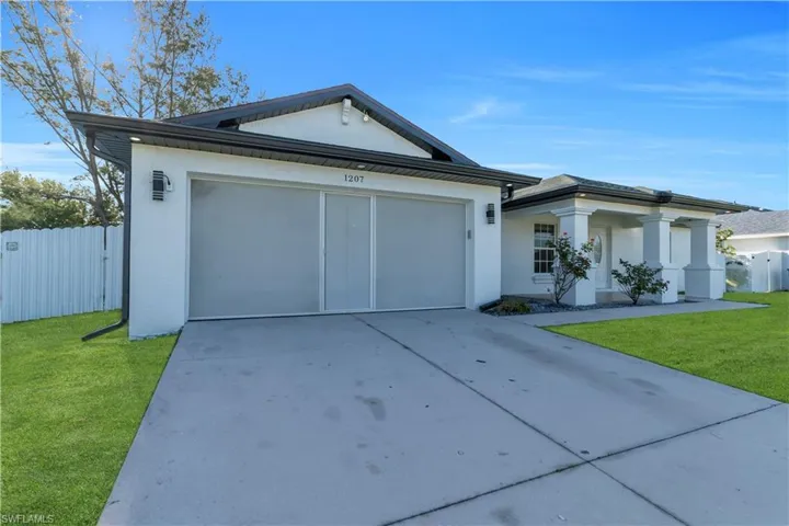 Single story home featuring concrete driveway, a garage, and stucco siding