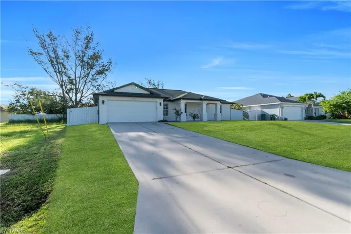 Single story home featuring an attached garage and concrete driveway