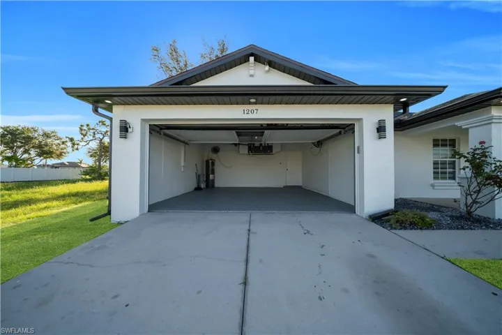 Garage featuring driveway and electric water heater