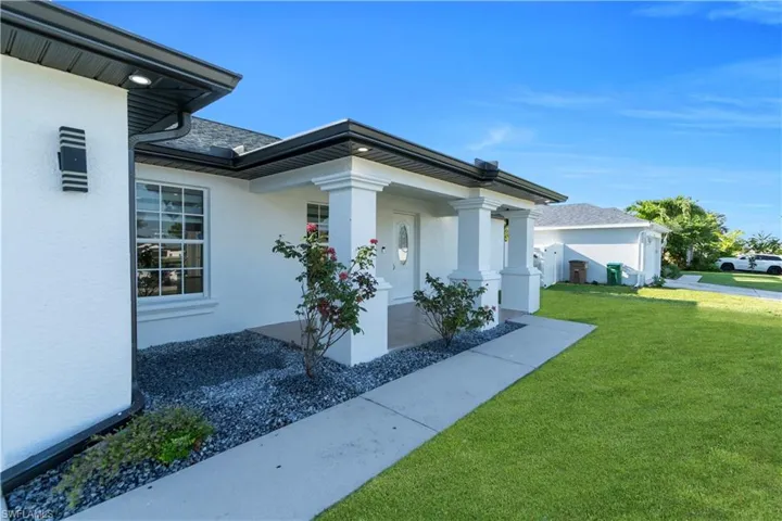 View of side of property featuring a yard and stucco siding