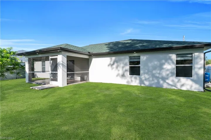 Back of property featuring a yard and a sunroom