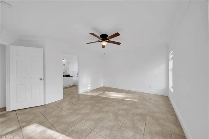 Spare room with ceiling fan and light tile patterned floors