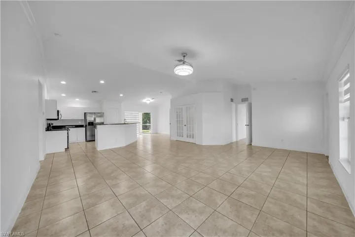 Unfurnished living room with light tile patterned flooring, recessed lighting, and vaulted ceiling