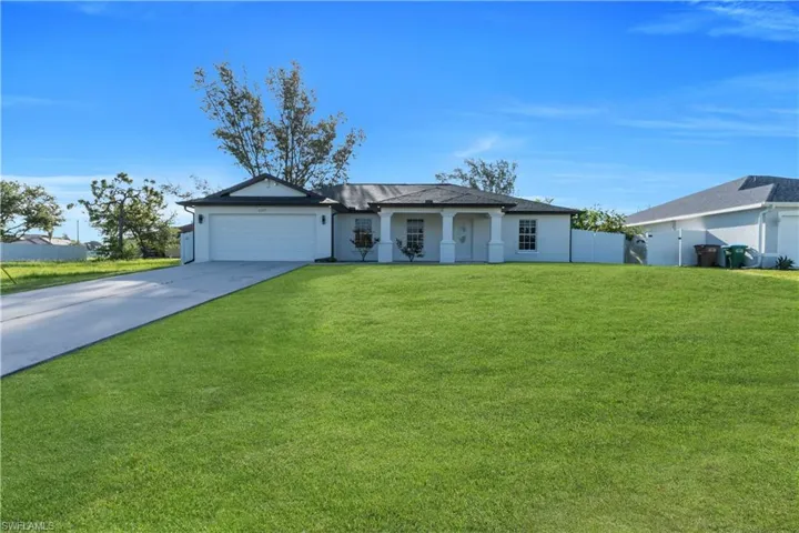 Ranch-style home featuring driveway, an attached garage, and stucco siding