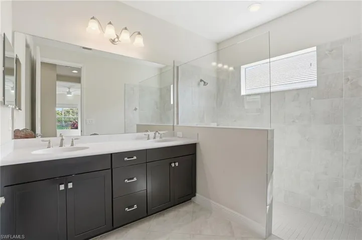 Primary bathroom with dual sinks and large walk in shower- Virtually enhanced