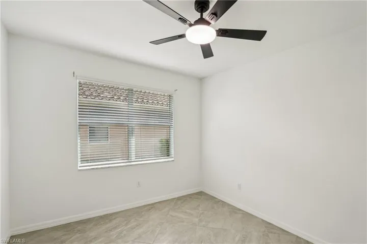 Unfurnished room with baseboards and a ceiling fan