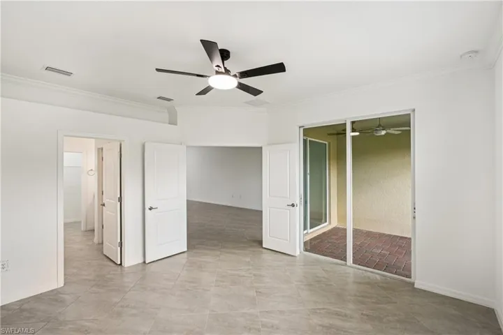 Unfurnished bedroom with crown molding, a closet, a ceiling fan, and light tile patterned floors