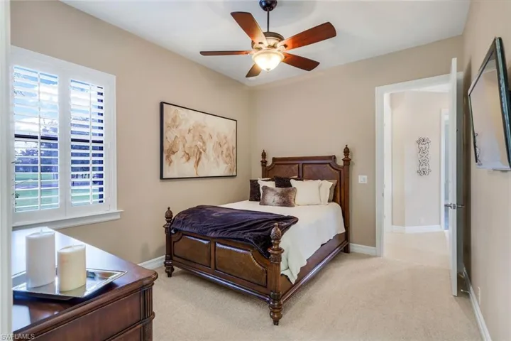 Bedroom with ceiling fan and light carpet