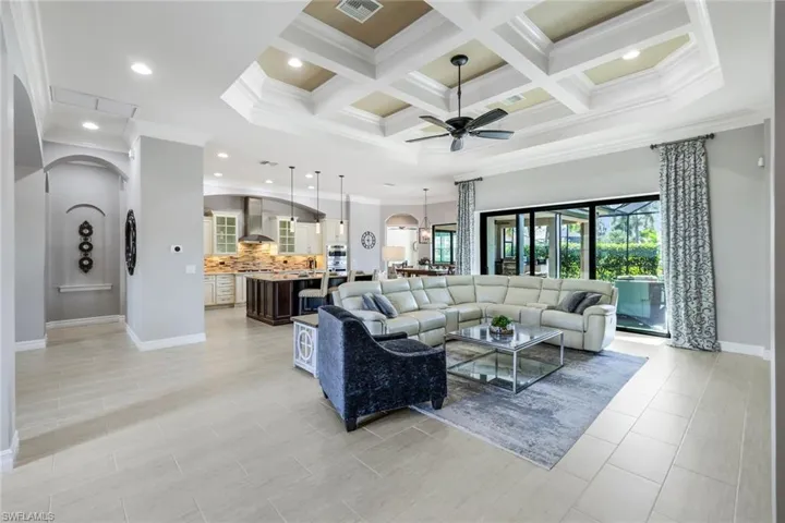 This spacious open-concept living area boasts light beige-gray walls and matching tile floors, creating a bright and cohesive space.