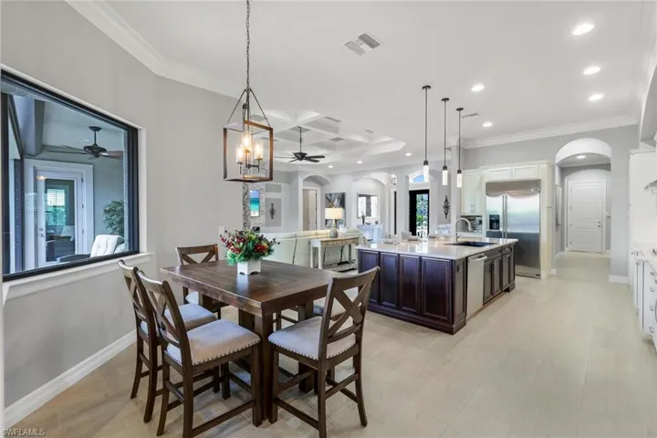 Dining room featuring crown molding, sink, beamed ceiling, and coffered ceiling