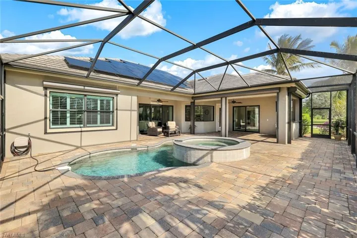View of swimming pool featuring ceiling fan, a lanai, a patio, and an in ground hot tub